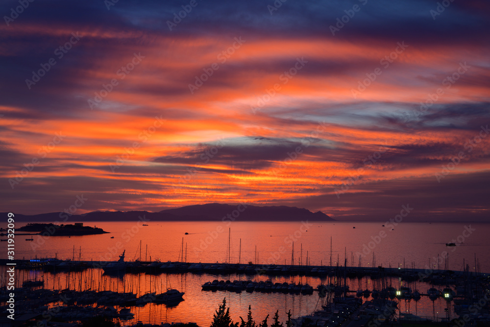 Fiery sunset at Kusadasi Turkey Harbour with Guvercin Adasi Island on the Aegean Sea with mountains of Samos Greece