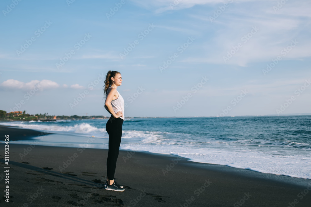 Young woman in sportswear against sky and sea Young woman in sportswear against sky and sea