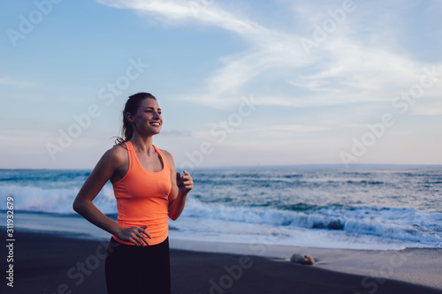 Sportive young woman jogging on beach