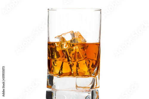 A glass of whiskey with ice or brandy and a square carafe isolated on a white background. Whiskey with ice in a glass against white background.