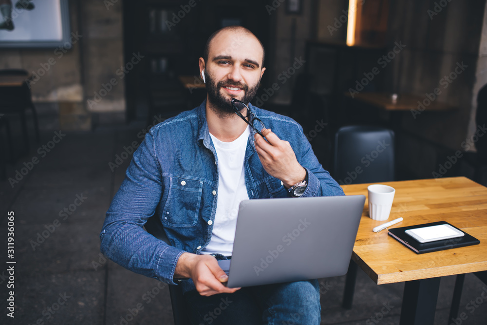 Cheerful male browsing laptop in cafe Cheerful male browsing laptop in cafe