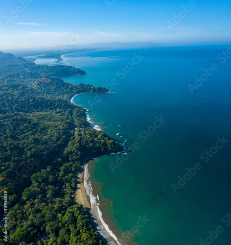 Aerial Drone View of a tropical beach in Costa Rica. Sand and water surrounded by lush rainforest