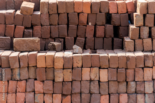 Stacked red bricks ready to use for construction