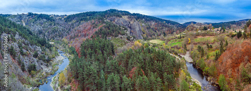 La Loire river flow and the Valley landscape panoramic view with Arlempdes medieval village at right, Paillasses Ravine is at left.  Haute-Loire in France, Auvergne-Rhone-Alpes region.