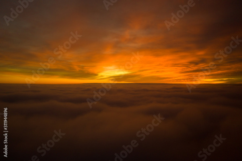 Beautiful sunrise cloudy sky from aerial view. Airplane view above clouds