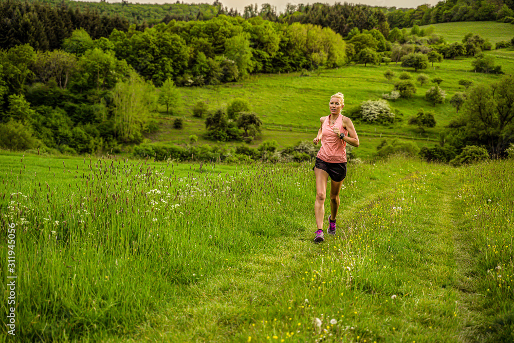 A middle-aged woman runs through the hills A middle-aged woman runs through the hills