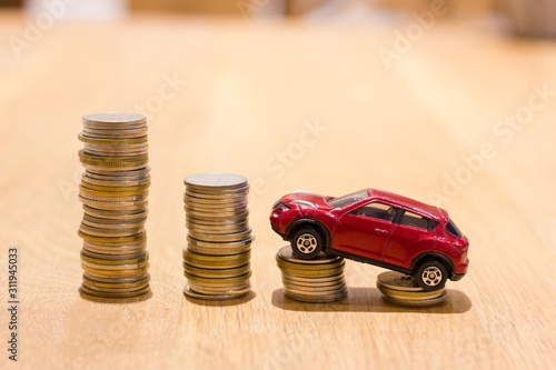 Red small car on stacks of coin. Finance and car loan concept.