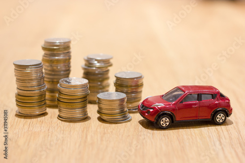 Red car and coin stacks on the table for finance about car concept.