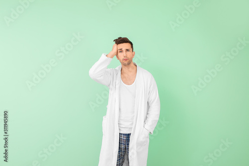 Sleepy man in bathrobe on c...