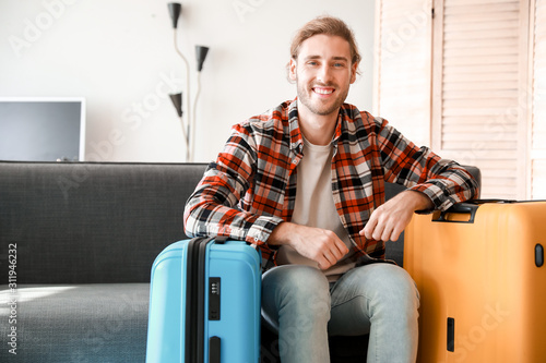 Young man with packed luggage at home © Pixel-Shot
