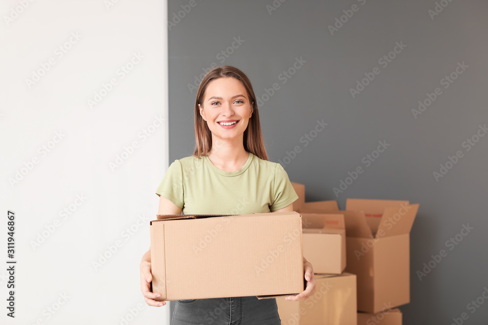Happy young woman with moving box in new house Happy young woman with moving box in new house