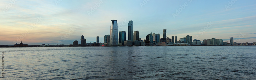 Naklejka premium Sunset at Jersey City skyline with panoramic view from Manhattan