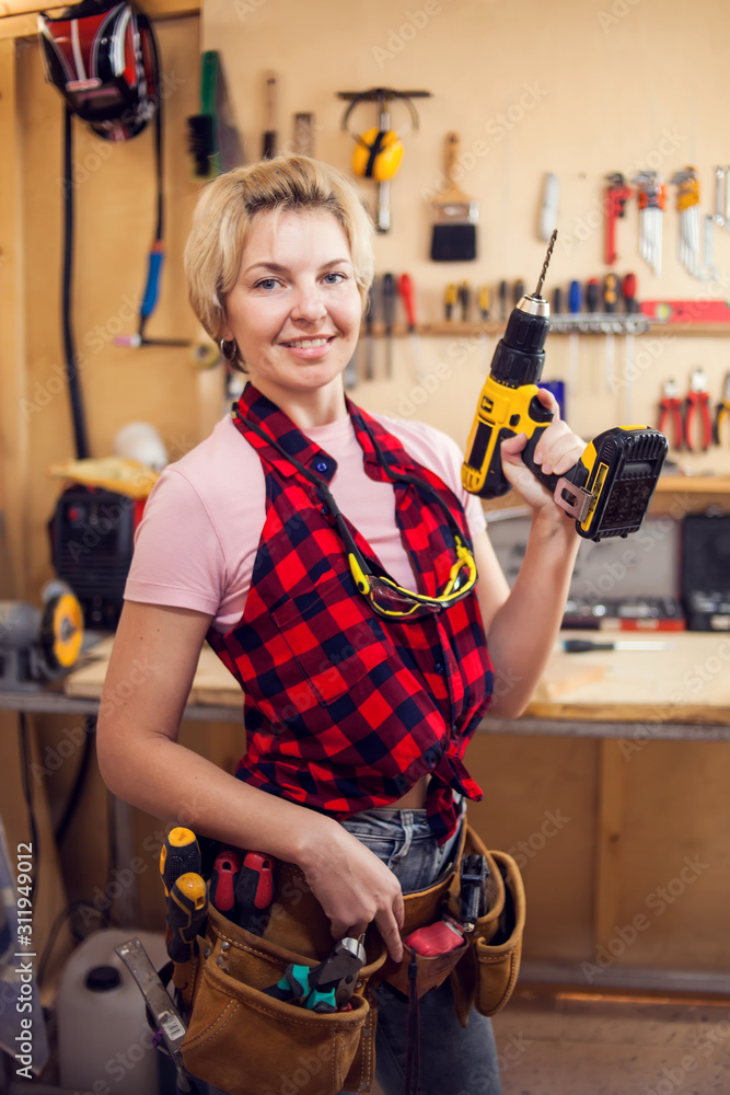 Young handy woman with short blond hair working with screwdriver. Young handy woman with short blond hair working with screwdriver.