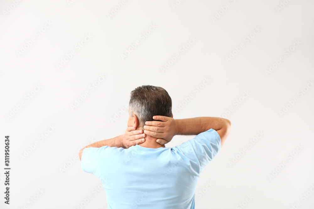 Mature man suffering from neck pain on white background Mature man suffering from neck pain on white background