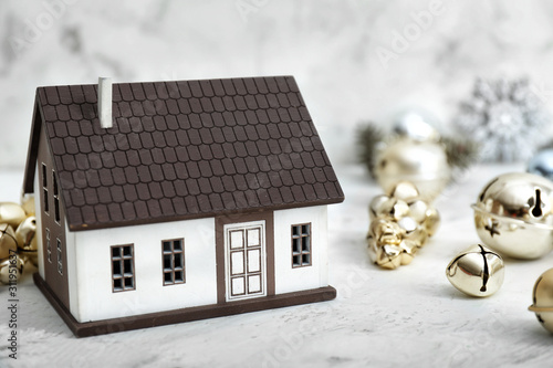 Figure of house and Christmas decor on table photo