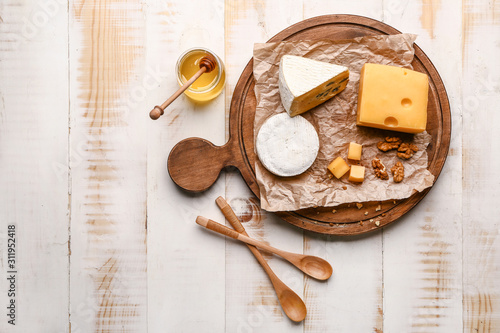 Assortment of fresh cheeses with honey on wooden table