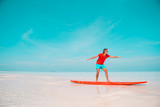 Happy young surf man on red surfboard at the sea