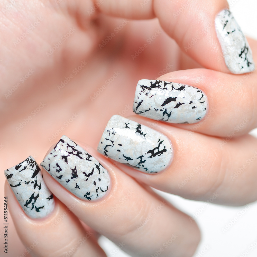 grey manicure with marblre effect with shimmer on a white background