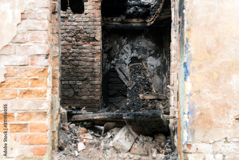 Doorway of a burnt brick house, charred boards after a fire. Doorway of a burnt brick house, charred boards after a fire.