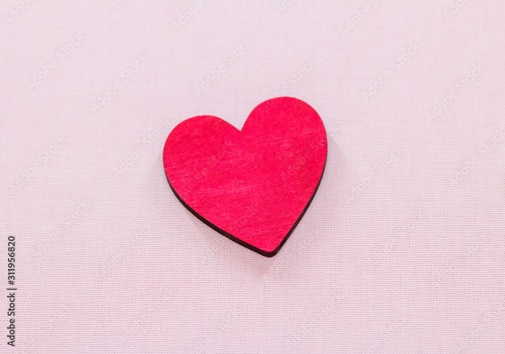 beautiful red wooden heart lies on a pink background beautiful red wooden heart lies on a pink background