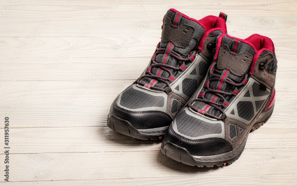 Female hiking boots on white wooden background