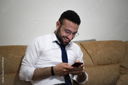 man after work looking his smartphone laughing