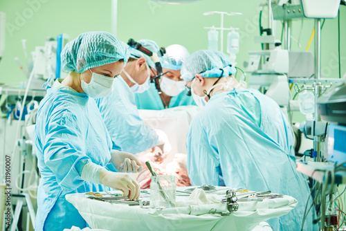 surgeons at work. female nurse at operation in child surgery hospital photo