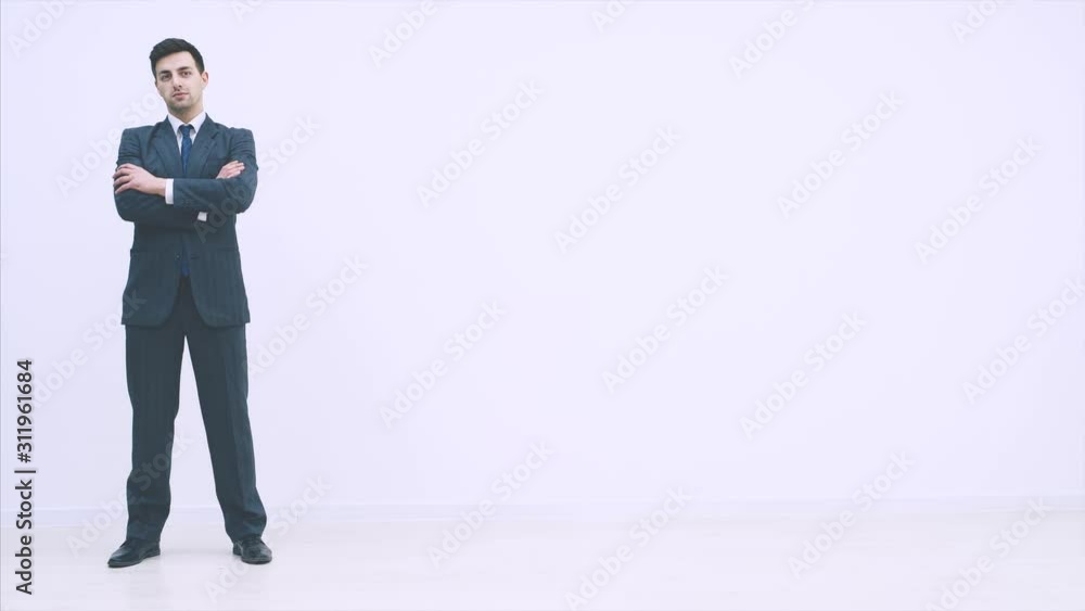 Serious handsome businessman appearing on the white background, folding his hands, looking confidently at the camera. Serious handsome businessman appearing on the white background, folding his hands, looking confidently at the camera.