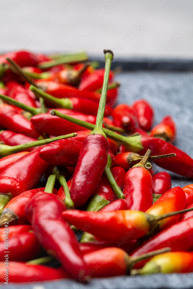 Fresh small red hot chili peppers on grey background Fresh small red hot chili peppers on grey background