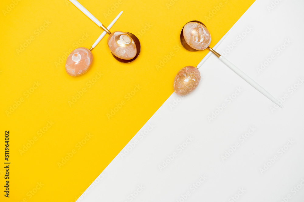 Easter border composition with golden decorated eggs on spoons on yellow backdrop. Stylish decor minimal easter concept. Copy space. Festive flat lay backdrop greeting card. Easter border composition with golden decorated eggs on spoons on yellow backdrop. Stylish decor minimal easter concept. Copy space. Festive flat lay backdrop greeting card.