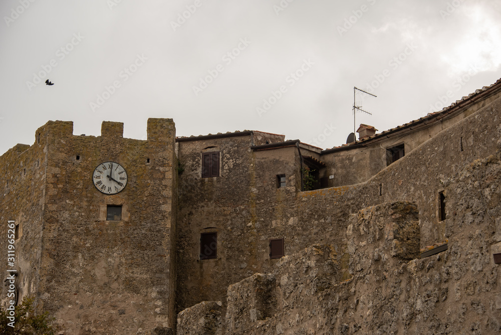 Old walls of Capalbio town under cloudy sky. Grosseto, Tuscany, Italy. 