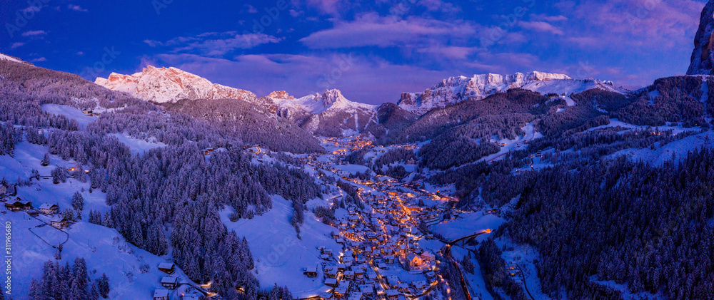 Aerial night view of the Val Gardena ski resort mountain village in Dolomites, Italy, Beautiful cozy village in winter time during Christmas. - obrazy, fototapety, plakaty 