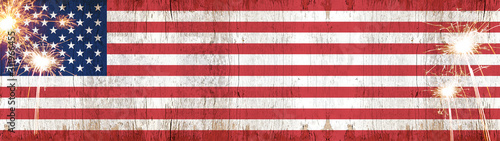 Happy 4th of July background panorama banner - American flag on wooden rustic vintage texture with sparklers and firework