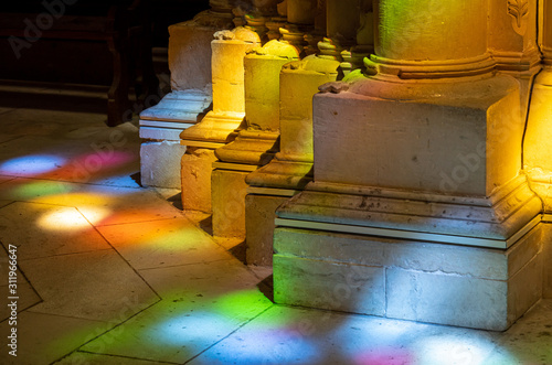 Photography Colored lights from stained glass windows on columns inside the Batalha Monaster