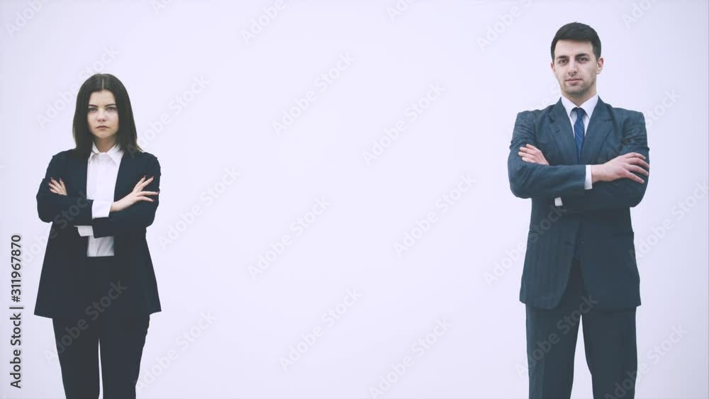 Confident business man and woman standing, folding their hands, looking at the copespace for text or product between them, nodding, giving thumbs up. Confident business man and woman standing, folding their hands, looking at the copespace for text or product between them, nodding, giving thumbs up.