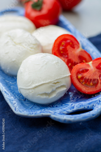 Cheese collection, fresh Italian soft mozzarella cheese in balls served with red ripe tomatoes