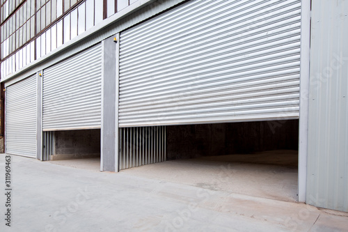 gray steel shutter of an industrial garage with gray concrete porch, side view nobody. photo