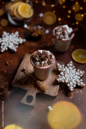 Christmas still life: cups with marshmallows and gingerbread on a brown background