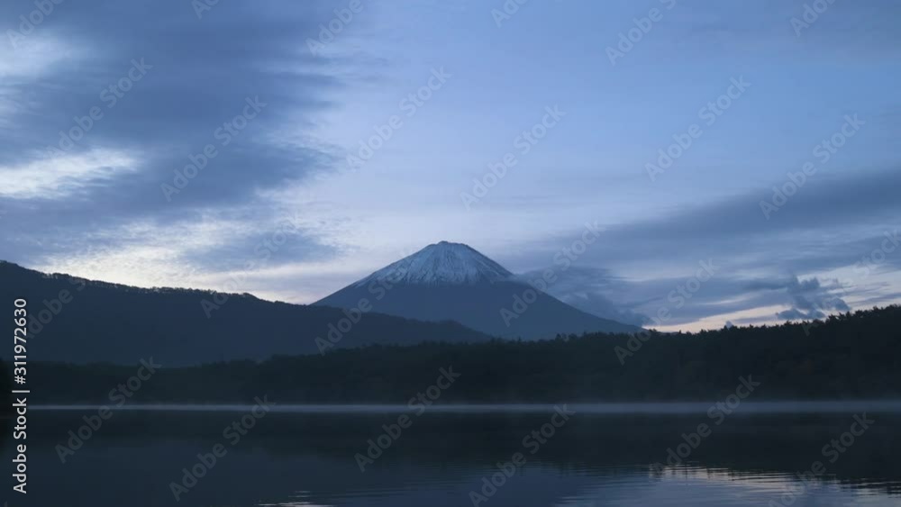 View of Mount Fuji at sunrise on a peaceful morning from lake Saiko, Yamanashi Prefecture, Japan View of Mount Fuji at sunrise on a peaceful morning from lake Saiko, Yamanashi Prefecture, Japan