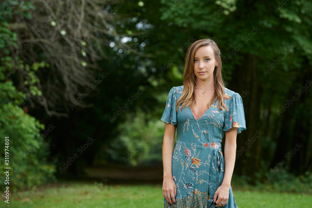 Stunning young Caucasian woman posing outside in park - summer themed in print wrap dress Stunning young Caucasian woman posing outside in park - summer themed in print wrap dress