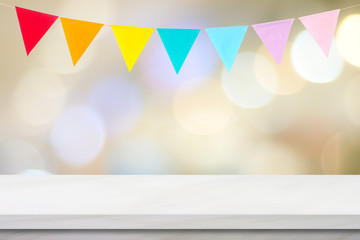 Colorful bunting party flags hanging onblur abstract bokeh light and white marble table background, birthday, greeting card background, banner, backgdrop, mock up, template, wallpaper