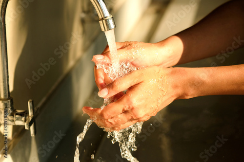 hand of beauty woman  wash your hands at the wash basin with foam, cleanse the skin and have water flowing through the hands. Health and beauty concepts