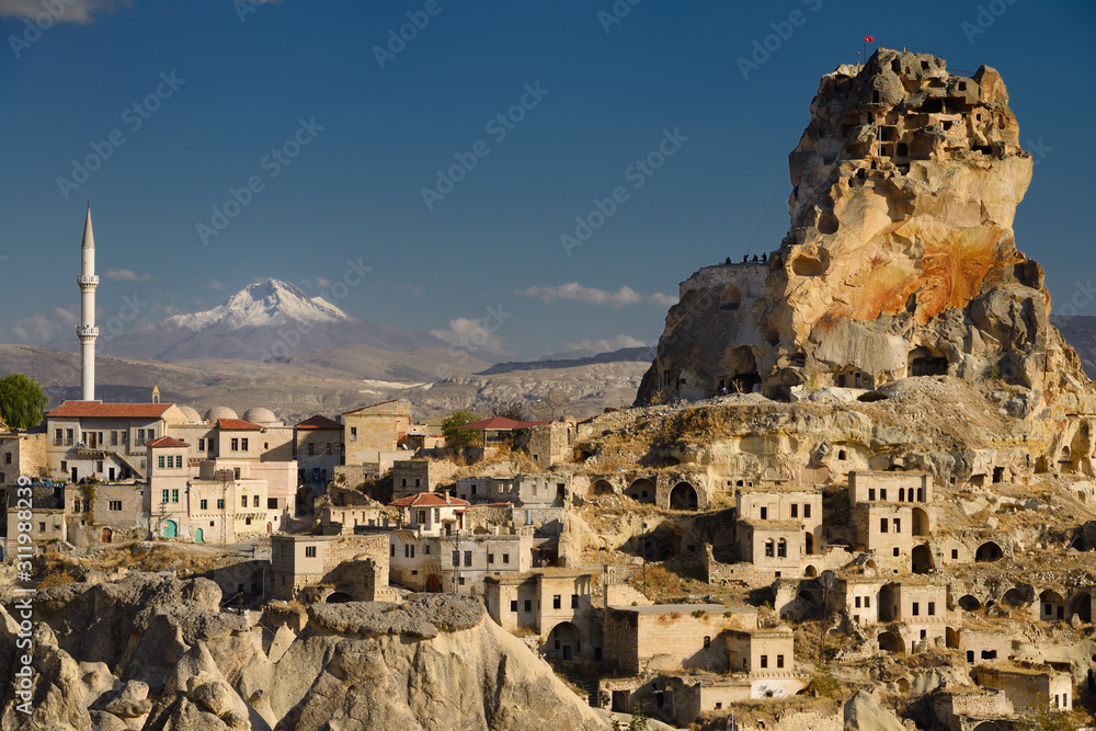 Ortasihar rock Castle with minaret Mount Erciyes and fairy chimneys Cappadocia Turkey
