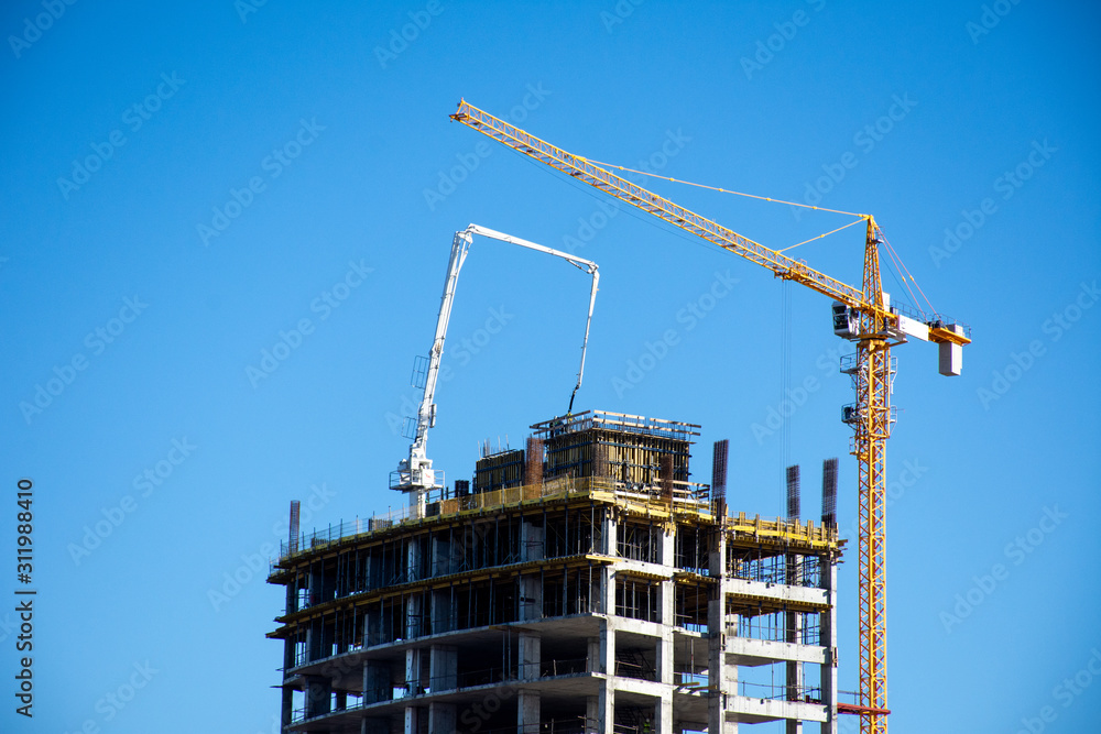 Ras al Khaimah building development building high rise hotel or apartment building complex with cranes and concrete on a beautiful blue sky day. Contruction concept.