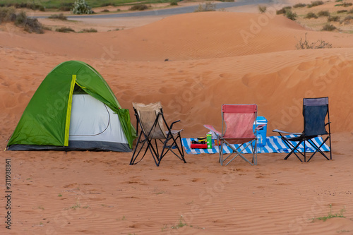 A green tent for family camping in the sand dunes of the United Arab Emirates desert. Family fun, isolated, quiet, arid.