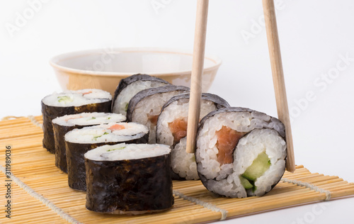 delicious Yin Yang sushi rolls on sticks on background and sushi roll on white background