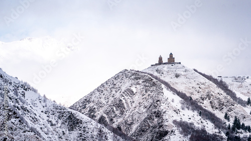 Gergeti trinity church in Stepantsminda during winter , Kazbegi mountain , Georgia photo