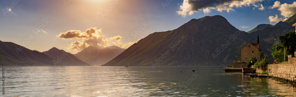 Old stone house in Kotor Bay with mountains and crystal clear water in the Balkans, Montenegro on the on Adriatic Sea