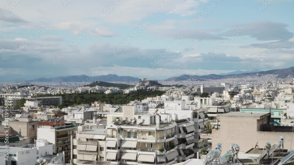 The city of Athens. The camera zooms in to the Acropolis and the Parthenon. It is a cloudy day. The city of Athens. The camera zooms in to the Acropolis and the Parthenon. It is a cloudy day.