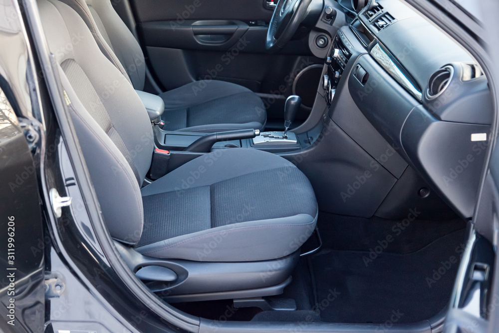 Comfortable front seats inside the car: the driver and passenger, tied with genuine black leather, modern interior design, the steering wheel covered with black wood and a luxurious center console. Comfortable front seats inside the car: the driver and passenger, tied with genuine black leather, modern interior design, the steering wheel covered with black wood and a luxurious center console.